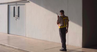 Security guard using walkie talkie while working in parking garage